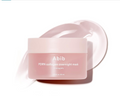 A jar of Abib PDRN collagen overnight mask in firming jelly, shown in a soft pink frosted container with a matching lid, set against a white background with a stylized smear of the pink mask behind it, Abib PDRN Collagen Overnight Mask Face Firming Jelly (2.7fl oz / 80ml)