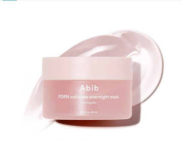 A jar of Abib PDRN collagen overnight mask in firming jelly, shown in a soft pink frosted container with a matching lid, set against a white background with a stylized smear of the pink mask behind it, Abib PDRN Collagen Overnight Mask Face Firming Jelly (2.7fl oz / 80ml)