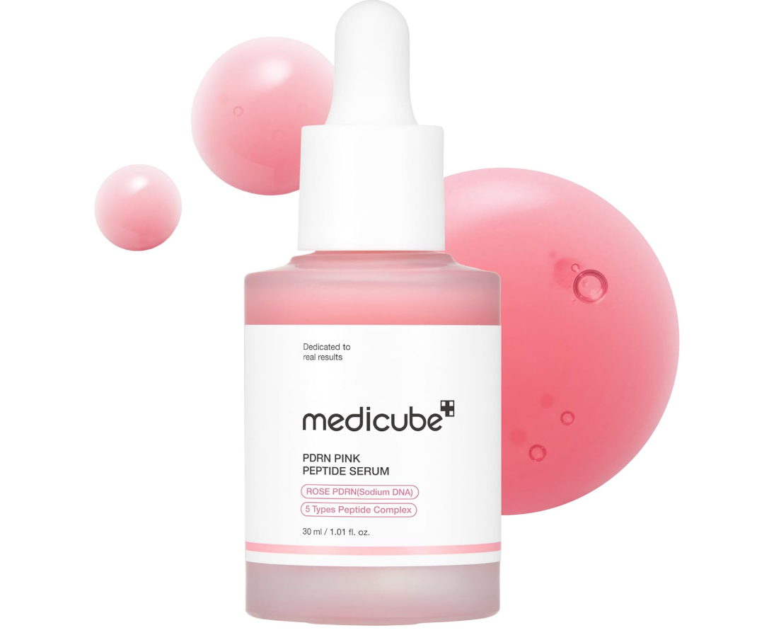 Medicube Poini Pink Peptide Serum in a frosted glass dropper bottle with a white cap and label, set against a white background with pink serum droplets. Medicube PDRN Pink Peptide Serum 30ml