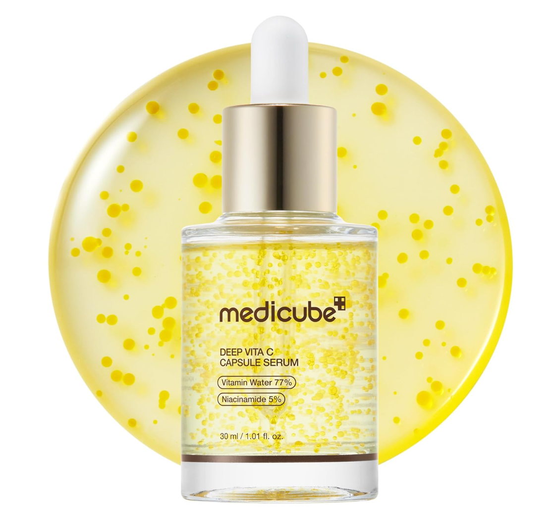 Medicube Deep Vita C Capsule Serum in a clear glass dropper bottle with a gold cap and white dropper, set against a yellow circular background filled with small yellow dots.\, Medicube Deep Vita C Capsule Serum 30ml