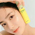 Person holding a yellow skincare product near their face against a light background, Goodal Green Tangerine VITA C Dark Circle Eye Cream 30ml