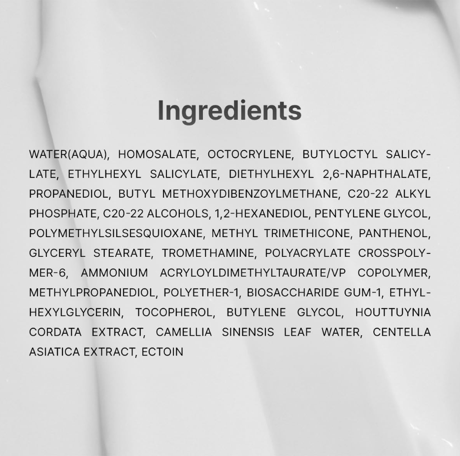 A close-up of a white cosmetic or skincare product surface with the word 'Ingredients' in dark gray text and a block of ingredient names printed below. Dr. Althea Green Tea Calming Sunscreen 50ml