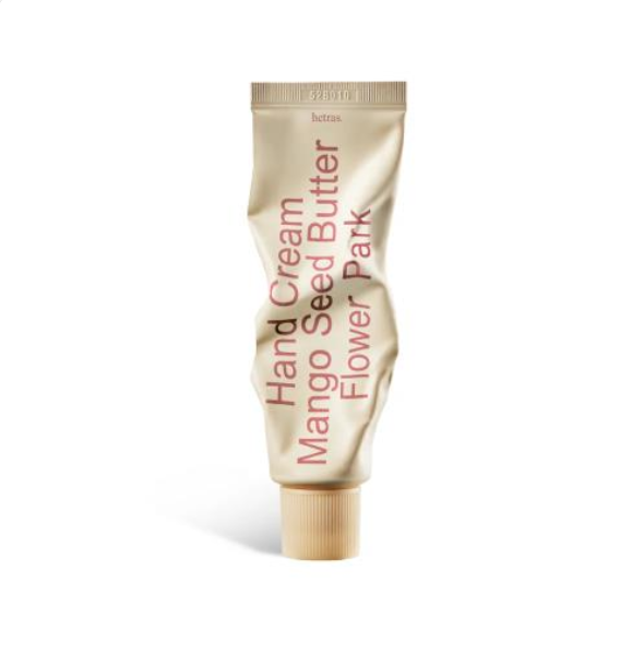 A squeeze tube of bettas Hand Cream Mango Seed Butter Flower Park hand cream, featuring a metallic gold tube with pink text and a gold cap, set against a plain white background. hetras Perfumed Mango Seed Butter Hand Cream Flower Park 50ml