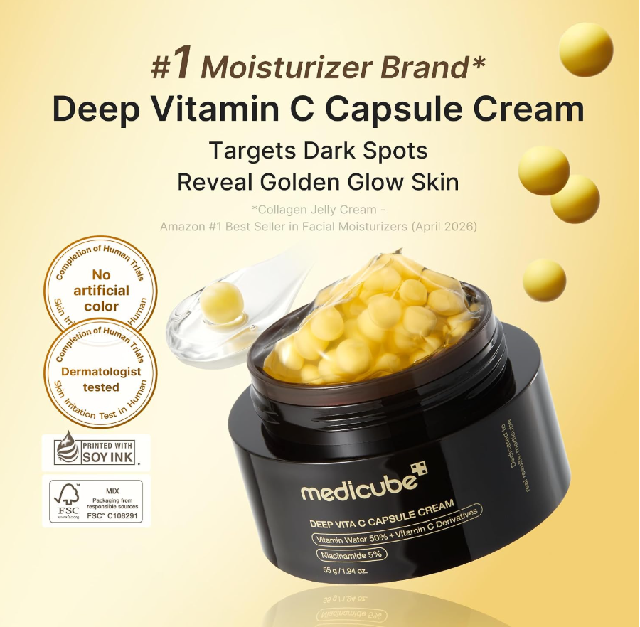Medicube Deep Vita C Capsule Cream in a black jar with a brown lid, shown open with yellow capsules visible and a clear spoon lifting some cream, on a white background. Medicube Deep Vita C Capsule Cream 55g