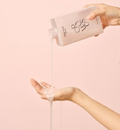 Person pouring a white liquid from a bottle labeled 'BCS' onto their hand against a pink background, Growus Damage Therapy Shampoo EX 500ml