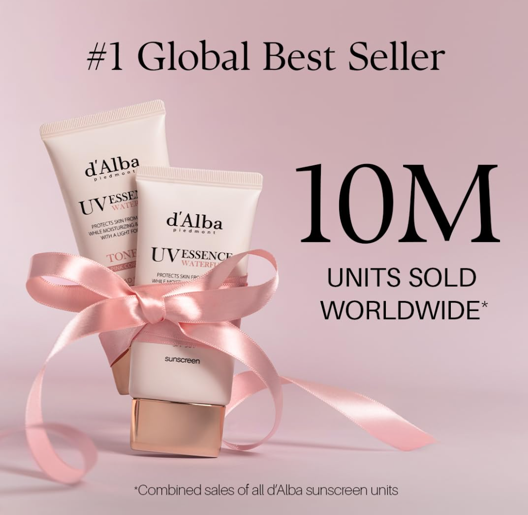 Two d'Alba sunscreen bottles with a pink ribbon on a light pink background, highlighting global sales achievement, D'Alba UV Essence Waterfull+ Tone-Up Pink Correcting SPF50 Sunscreen 50ml