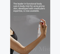 A person sprays a white body mist bottle with red accents into the air against a gray background, with promotional text at the top and a faint product name watermark at the bottom, Medicube Red Clear Cica Body Mist 200ml