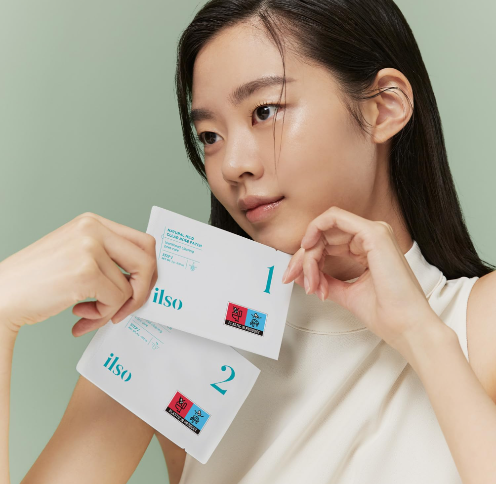 Woman holding Ilso skincare product packets against a light green background, Ilso Natural Mild Clear Nose Patch