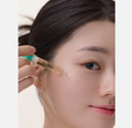 Close-up of a woman applying a cosmetic product to her face with a dropper, Dr.cpu+ Vitamin + Glutathione Booster Ampoule 30ml